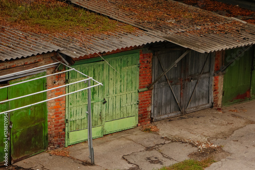 Old vintage garages with green door and red brick walls in Ukrai photo