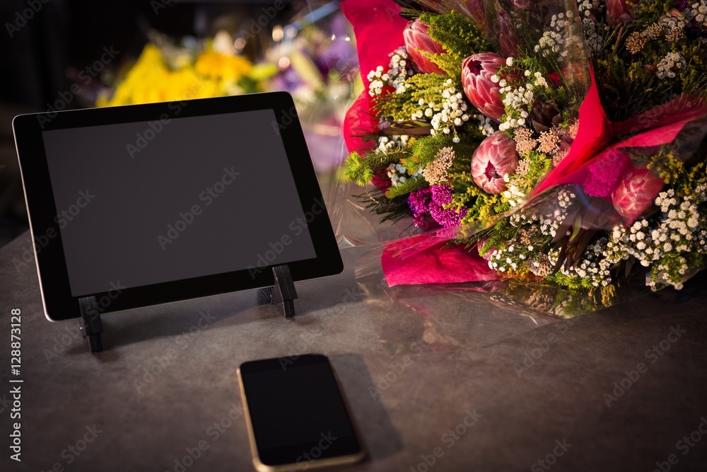 Flower bouquet with smartphone and digital tablet on the table Flower bouquet with smartphone and digital tablet on the table