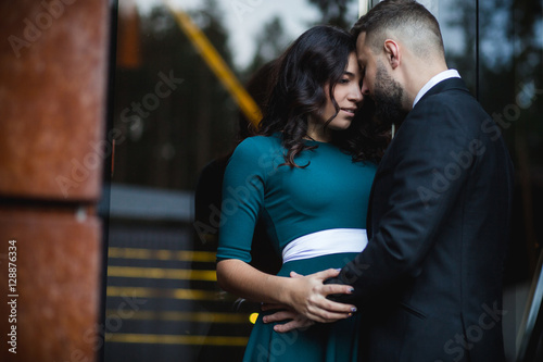 Couple in love - Beginning of a Love Story. A man and woman in evening dress, embrace and kiss while walking