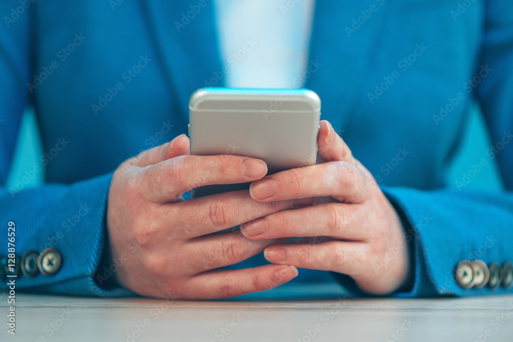 Businesswoman using smartphone, close up of hands