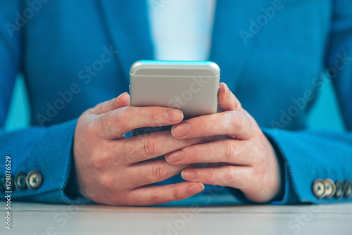Businesswoman using smartphone, close up of hands