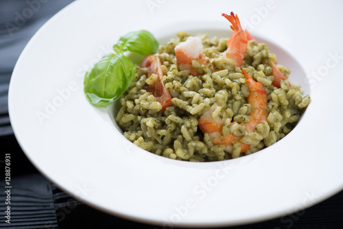 Risotto with spinach, tiger shrimps and tomatoes, close-up