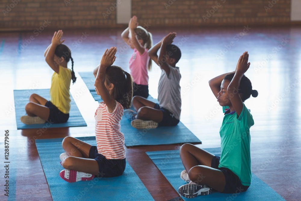 Fototapeta premium School kids meditating during yoga class