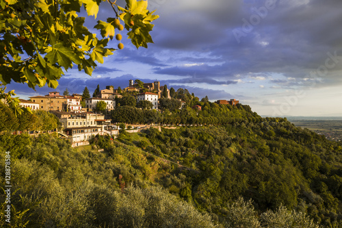 Vista panoramica di Montecatini Alto durante un tramonto caldo con nuvole blu violacee sullo sfondo.