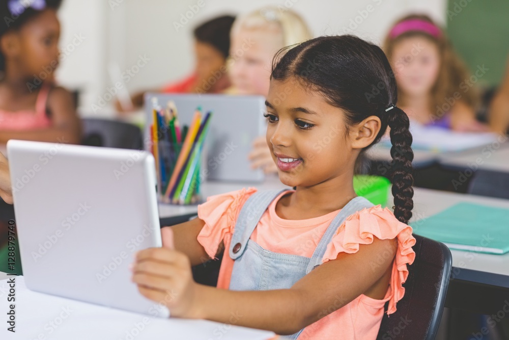 Schoolgirl using digital tablet in classroom Schoolgirl using digital tablet in classroom