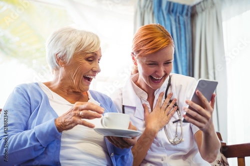 Senior woman and nurse using digital tablet