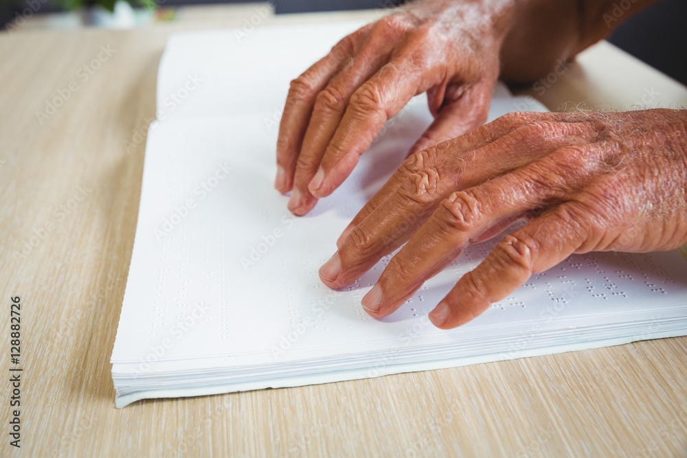 Senior man using braille to read Senior man using braille to read