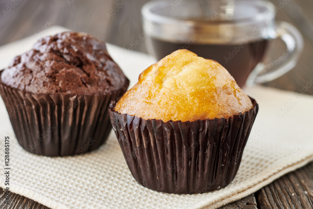 Muffins and a cup of tea on a wooden background