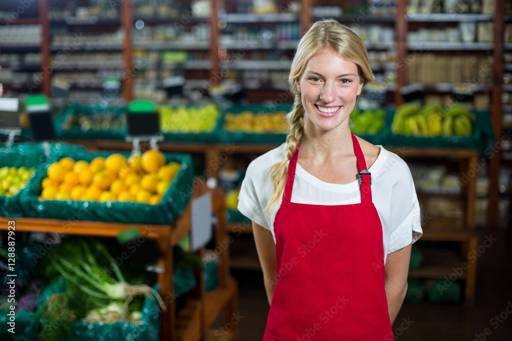 Smiling female staff standing in organic section