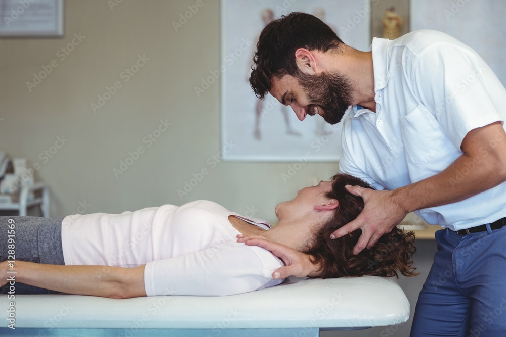 Physiotherapist giving neck massage to a woman Physiotherapist giving neck massage to a woman