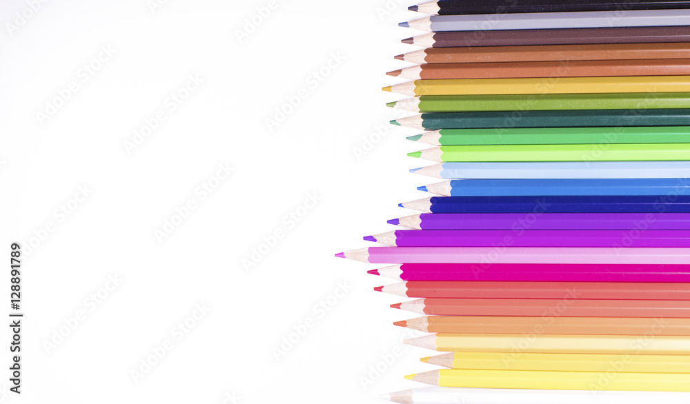 Fototapeta premium Jagged row of coloured pencils on white with space for text