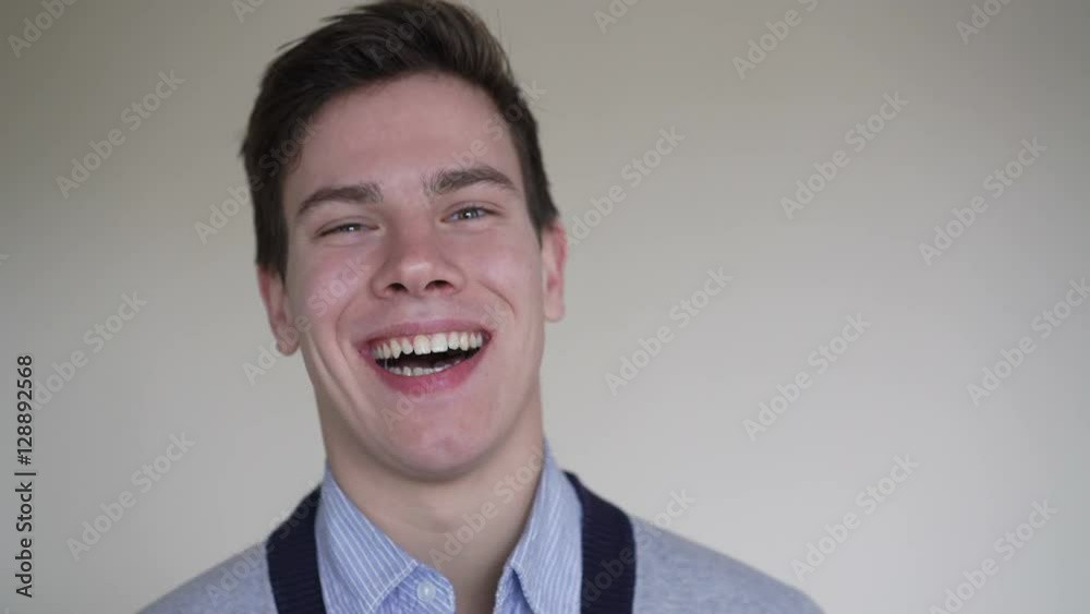 Young man looking seriously at camera and smiling in 4K Young man looking seriously at camera and smiling in 4K