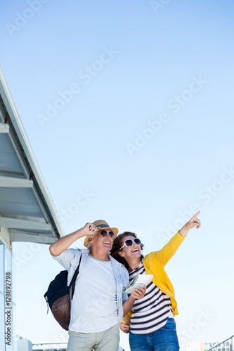 Woman with man pointing against clear sky