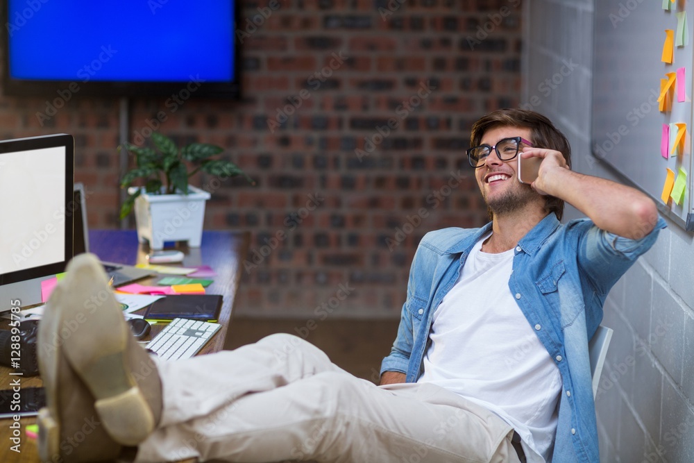 Fototapeta premium Smiling man talking on phone in office