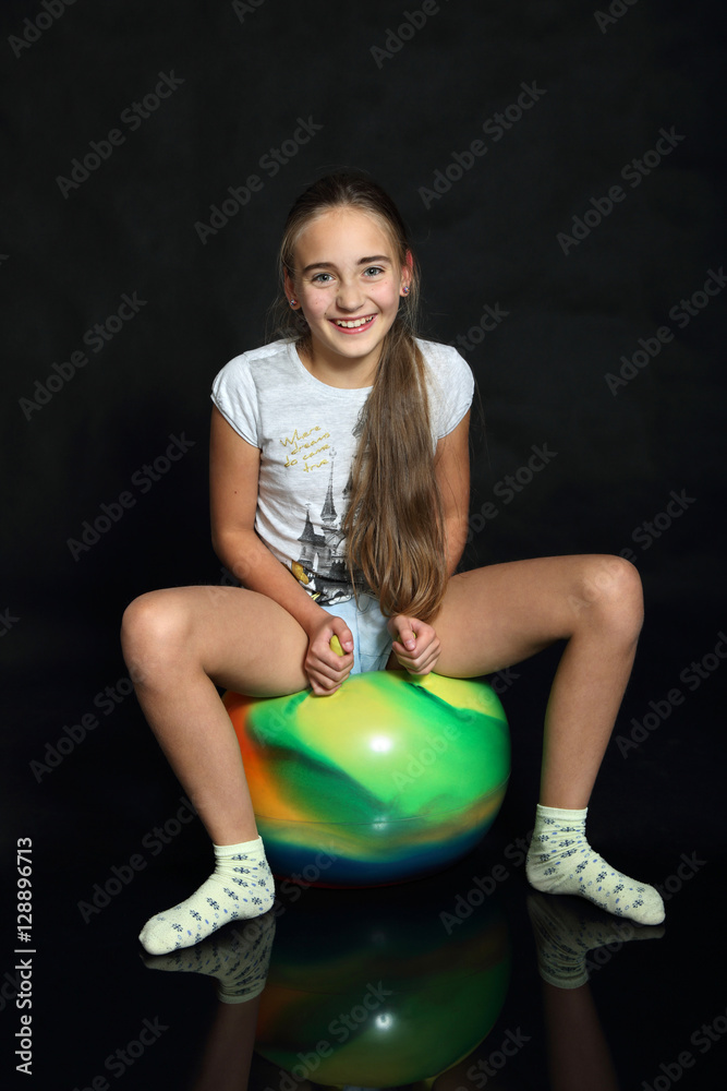 Śliczna dziewczynka,nastolatka siedzi na piłce z uszami. Stock Photo ...