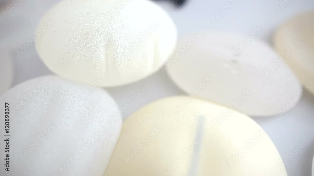 Close-up shot of breast implants on the table at beauty clinic office. Breast augmentation, enlargement, enhancement. Cosmetic surgery. Silicone breast implant. Plastic surgery. Close-up shot of breast implants on the table at beauty clinic office. Breast augmentation, enlargement, enhancement. Cosmetic surgery. Silicone breast implant. Plastic surgery.