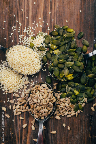 Sesame, pumpkin and sunflower seeds on wooden background