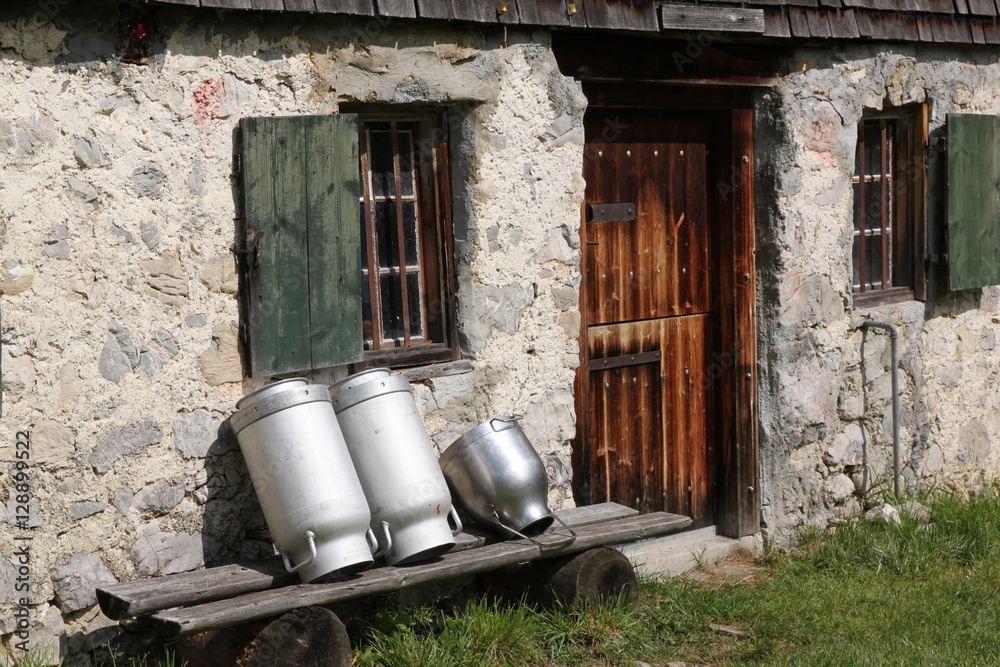 Milk cans in front of beautiful Bavarian alm Milk cans in front of beautiful Bavarian alm