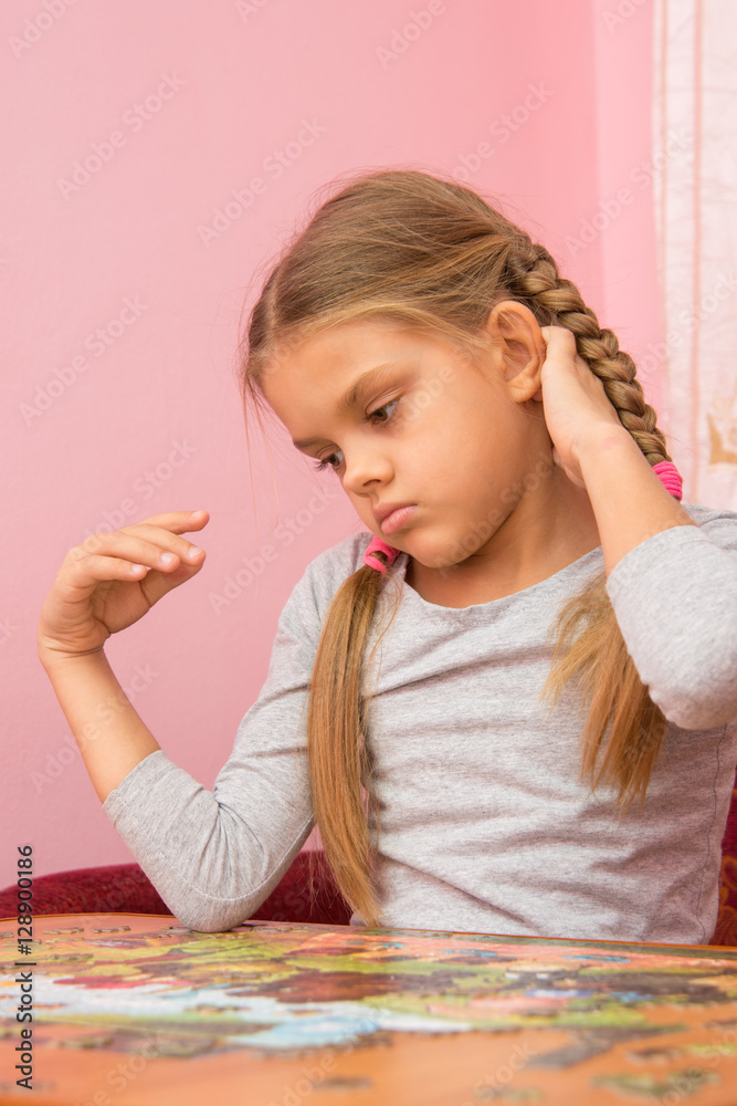 Girl thinks collecting picture of puzzles Girl thinks collecting picture of puzzles