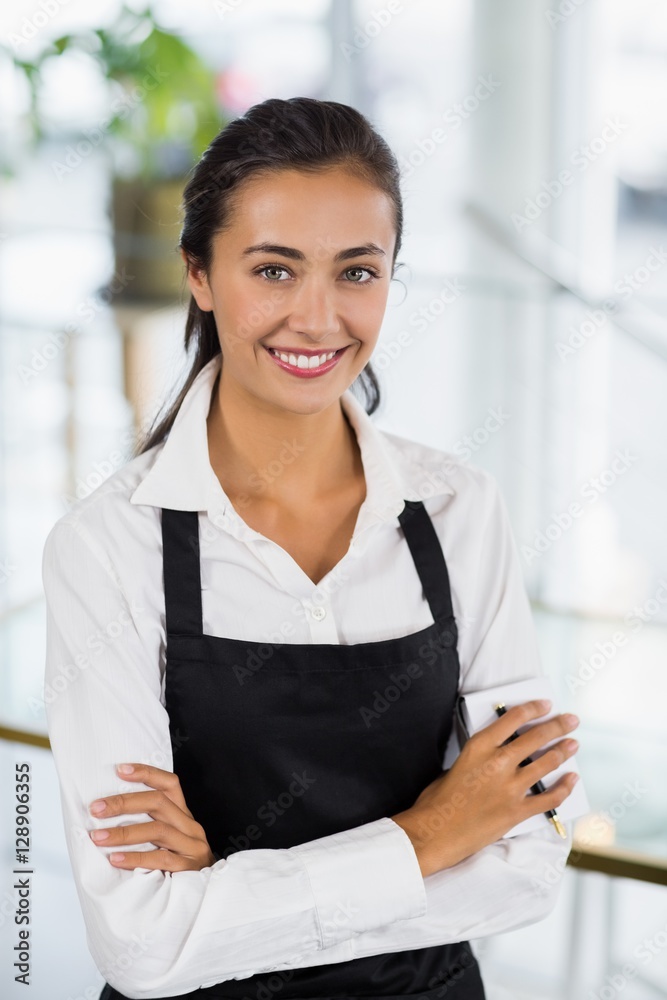 Portrait of smiling waitress standing with arms crossed Portrait of smiling waitress standing with arms crossed