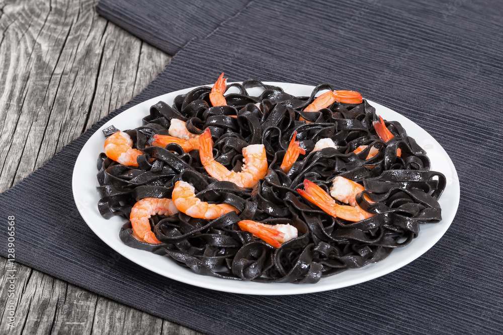 tasty Cuttlefish ink black noodles with prawns on white dish tasty Cuttlefish ink black noodles with prawns on white dish