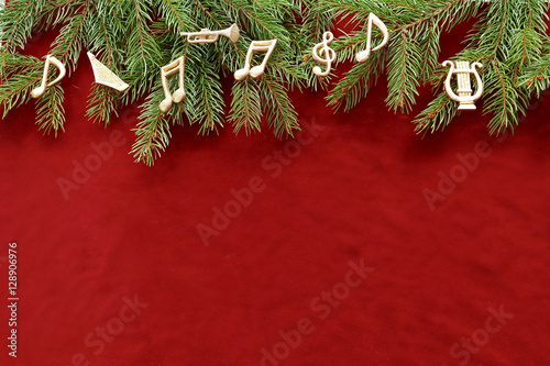 Musical notes, instruments on christmas tree brunch on red velvet 
