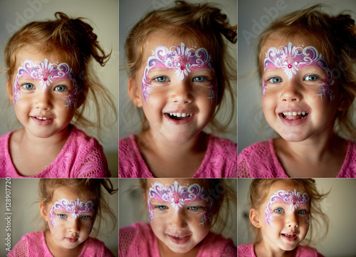 Pretty exciting blue-eyed girl of 2 years with a pink face painting © gal2007