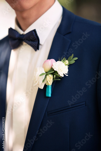 luxury stylish groom with boutonniere on elegant suit and bow tie close-up at wedding ceremony