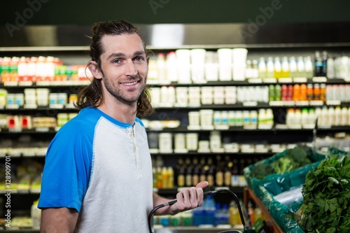Man holding shopping basket in supermarket