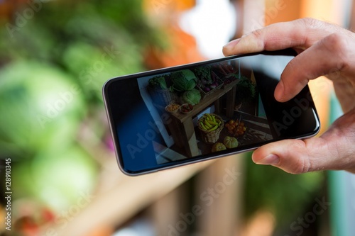 Photography Hand taking a photo of fruits and vegetables
