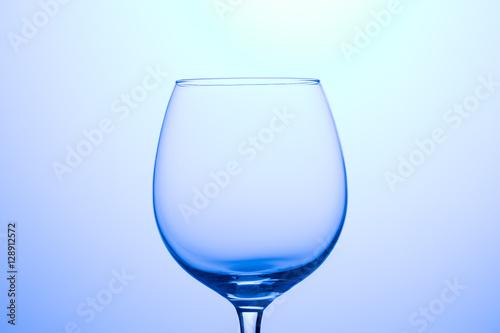 Empty glass for wine on blank blue background