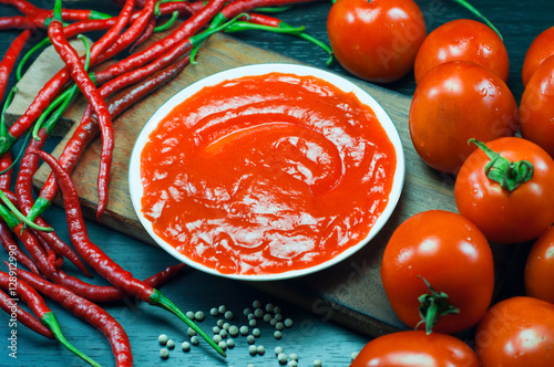 photo of tomato, chili and pepper as the manufacture of tomato sauce is very spicy and natural. in the photo with a dark background photo