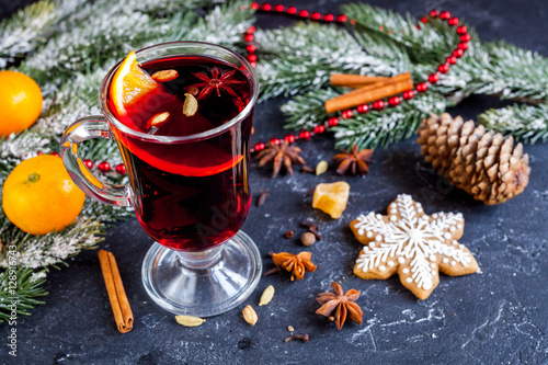 Christmas mulled wine with spices in cup on dark background