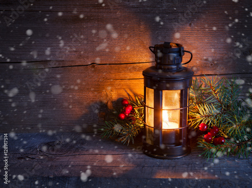 Cristmas lantern in night on old wooden background. focus on the wick candles