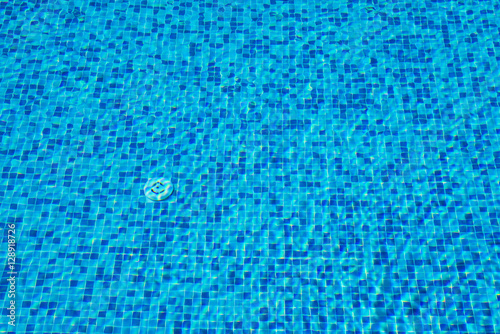 Background of a blue tiled pool with clear cool rippling water