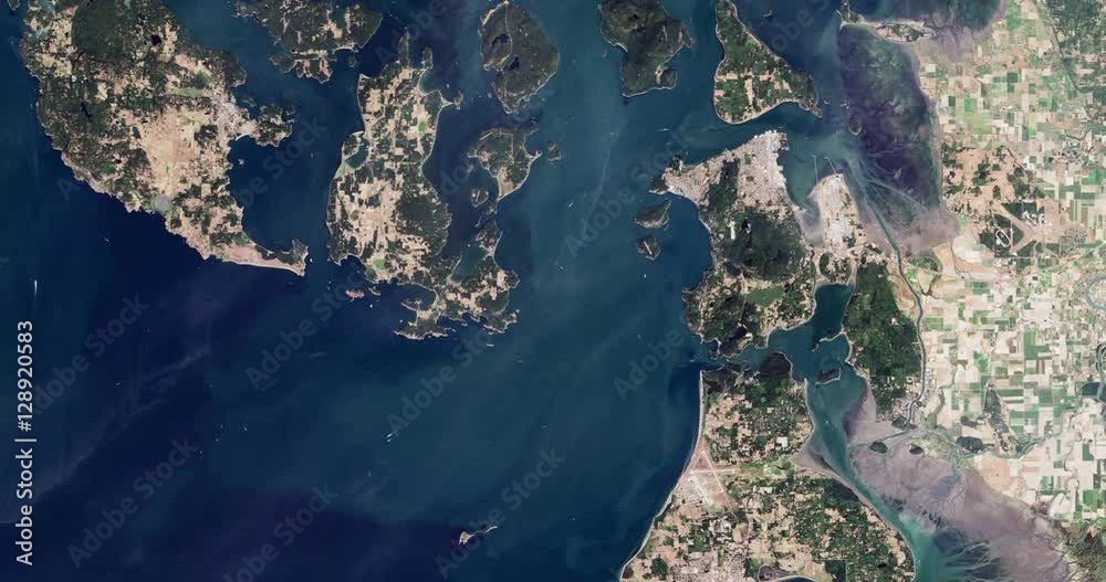 High-altitude overflight aerial of the San Juan Islands and NW Washington. Clip loops and is reversible. Elements of this image furnished by USGS/NASA Landsat 