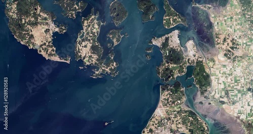 High-altitude overflight aerial of the San Juan Islands and NW Washington. Clip loops and is reversible. Elements of this image furnished by USGS/NASA Landsat 