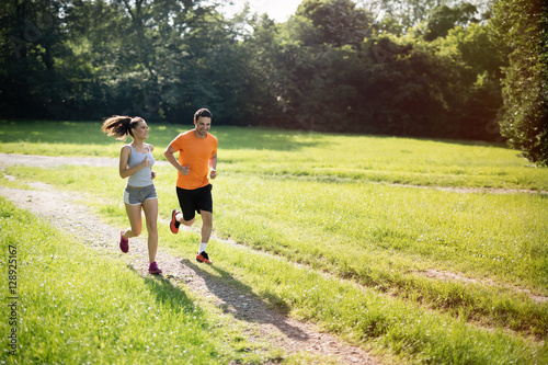 Healthy fit couple running in nature