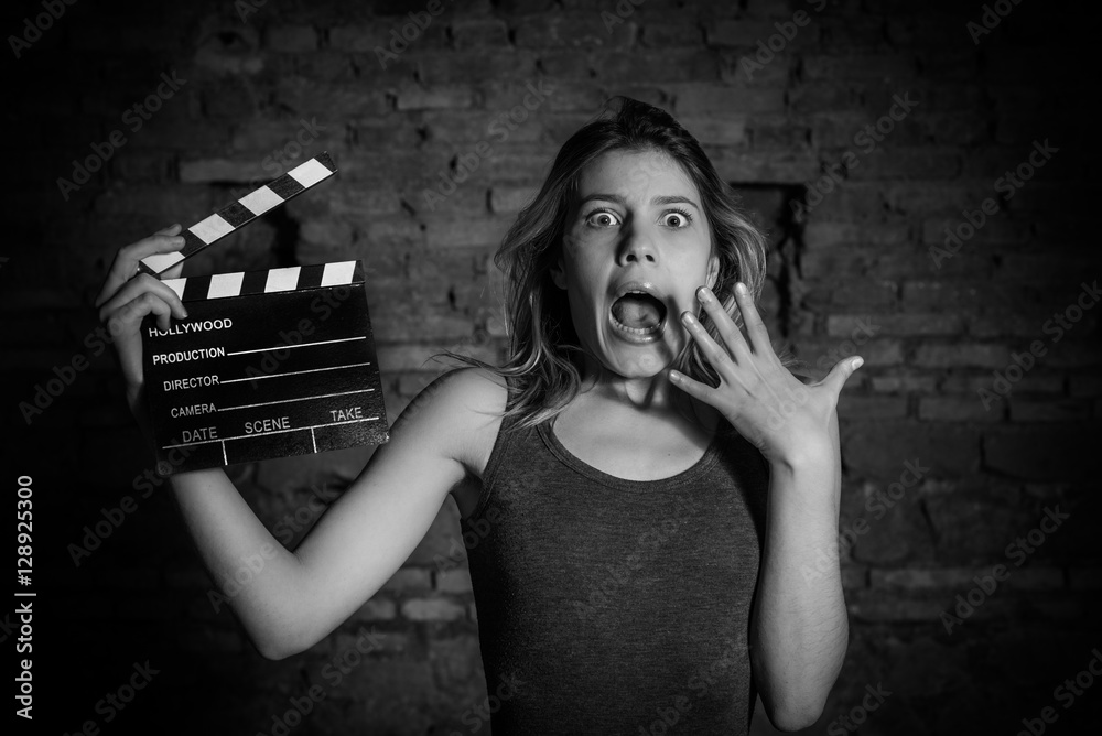 Obraz premium Young blonde actress shocked with movie clapper