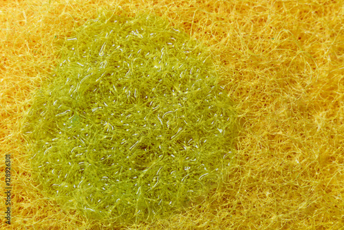 Texture yellow sponge and green dishwashing detergent. Macro © savelov