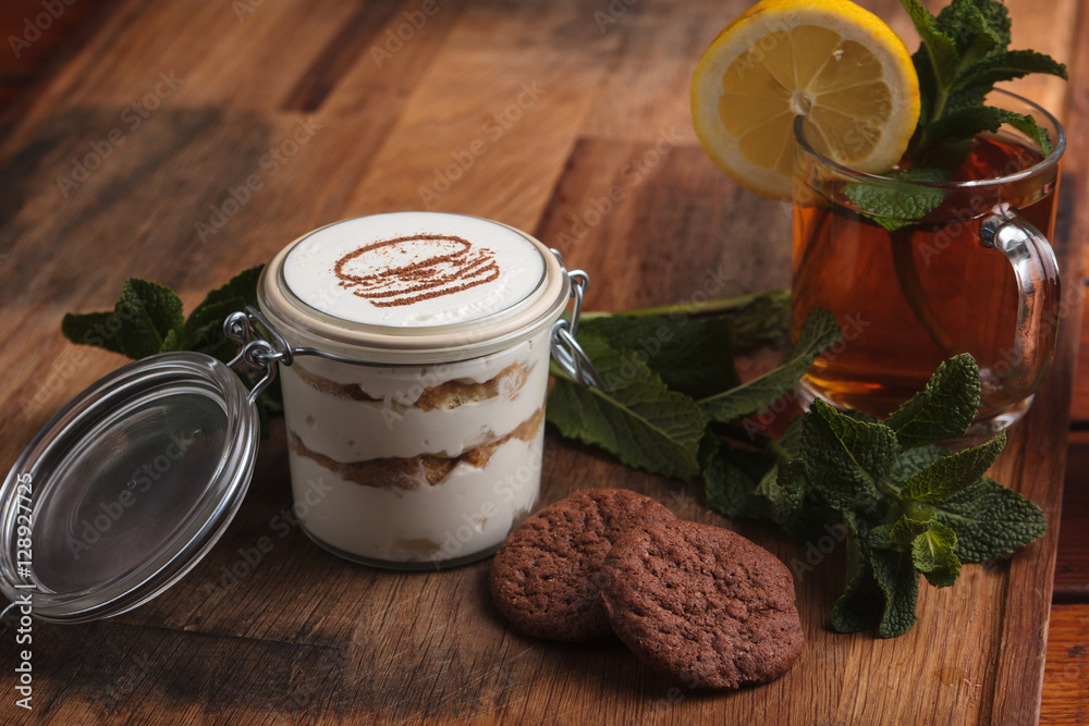 Concept: restaurant menus, healthy eating, homemade, gourmands, gluttony. Tiramisu dessert with cookies on weathered wooden table. Concept: restaurant menus, healthy eating, homemade, gourmands, gluttony. Tiramisu dessert with cookies on weathered wooden table.