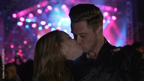 Young people hooking up in night club, couple kissing and dancing at party