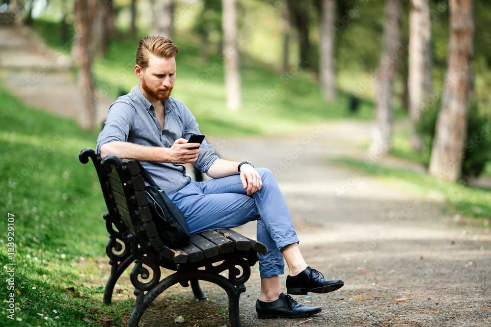 Handsome guy using phone in park Handsome guy using phone in park