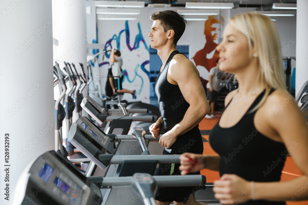 People running on treadmills in gym People running on treadmills in gym
