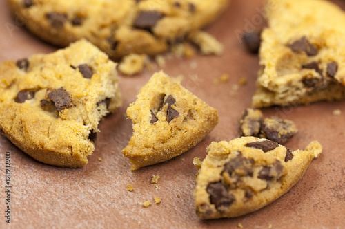 Broken chocolate chip cookies on a tiled worktop