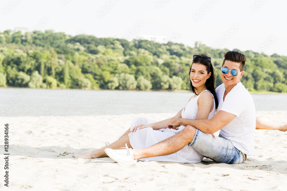 Romantic young couple sitting at a beach