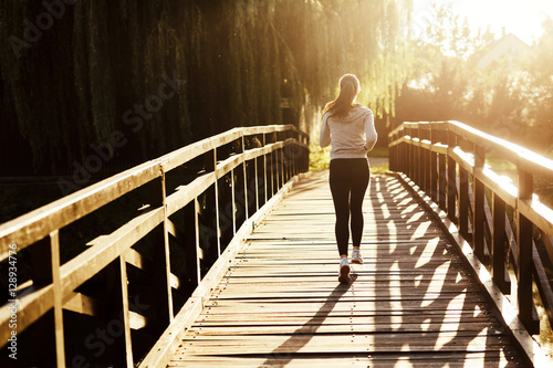 Beautiful female jogger running during sunset