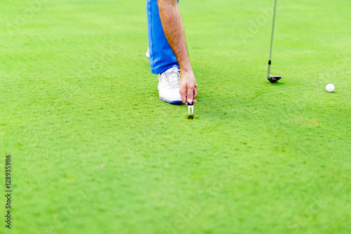 Golf player repairing divot