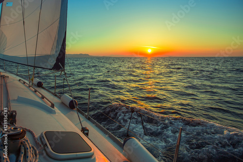 Sailing in the wind through the waves during sunset at the Aegean Sea in Greece. Luxury yachts.