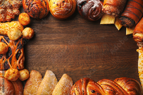 Frame of assorted fresh pastries on wooden background